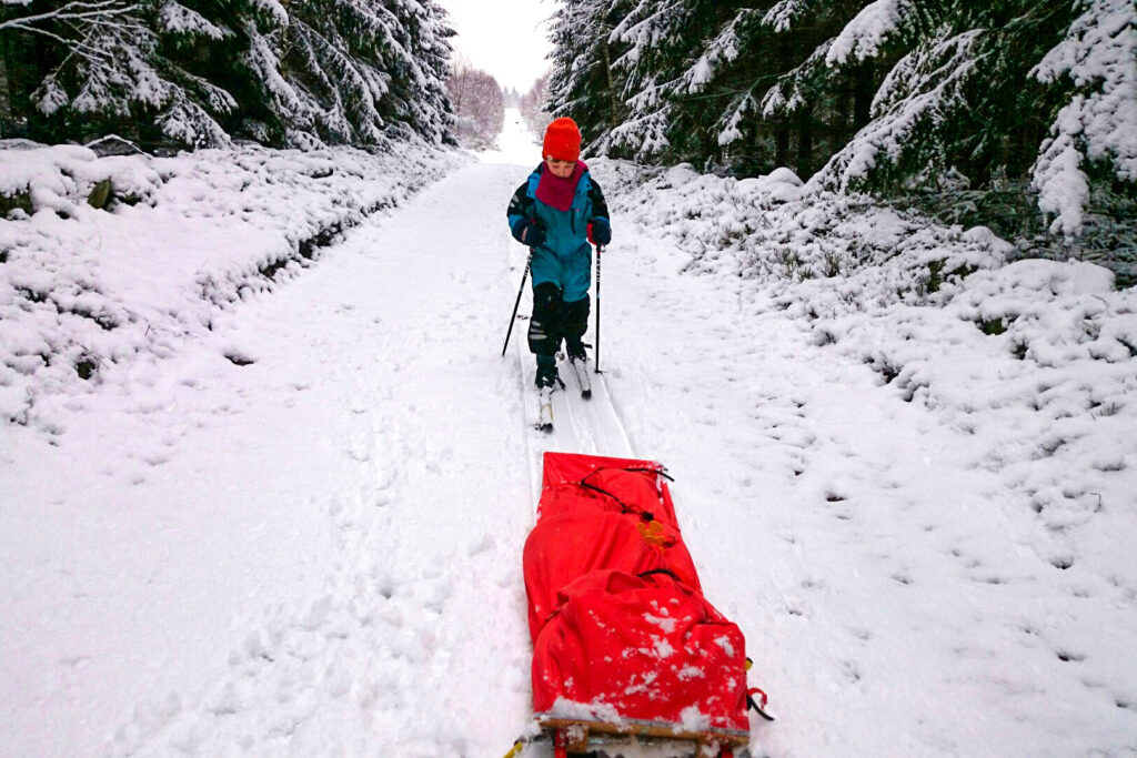 Medan storebror ångar på i spåret sover lillasyster middag i pulkan. Foto: Fabian Rimfors